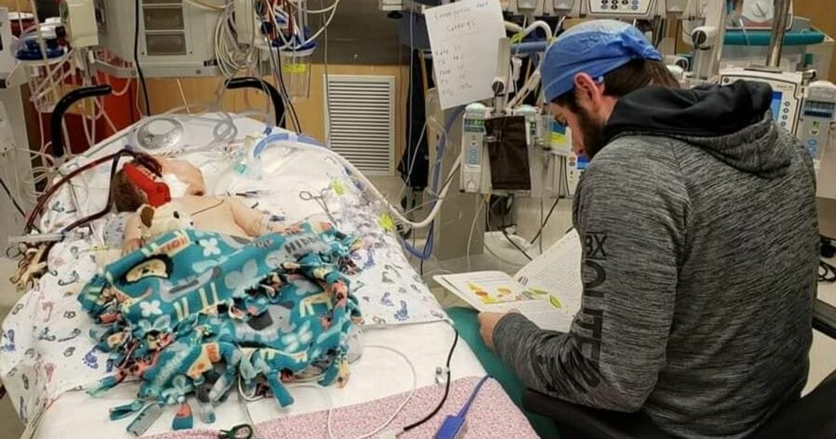 Cardiovascular perfusionist Dane Bratt reads a book to baby Parker Lynn, who was born prematurely in 2019 and suffers from chronic lung disease.