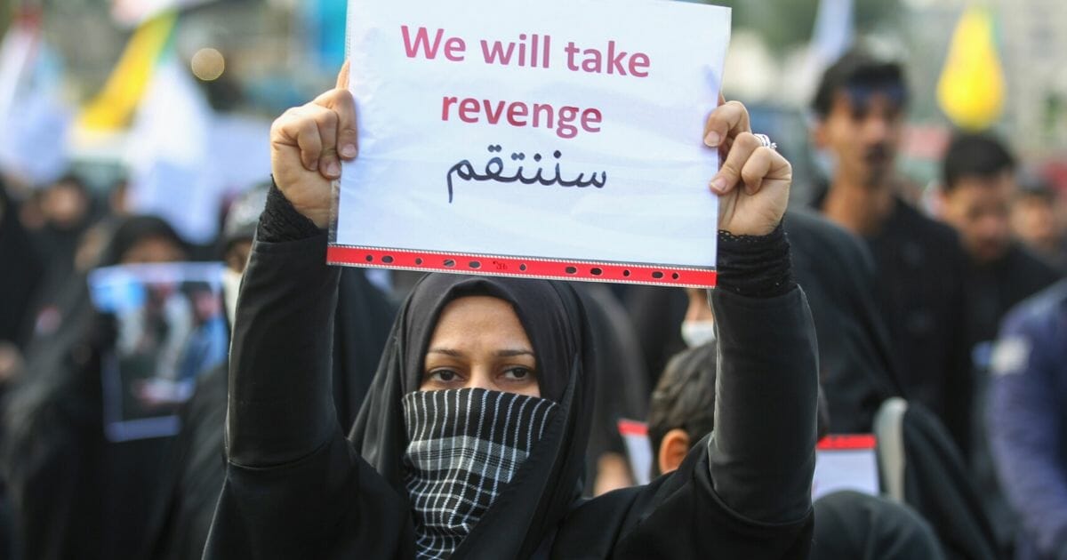 An Iraqi woman holds a placard during the funeral of Iranian military commander Qasem Soleimani in Baghdad on Jan. 4, 2020.