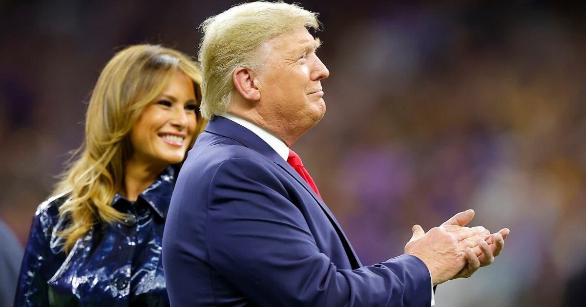 President Donald Trump applauds as first lady Melania Trump smiles Monday at the College Football Playoff National Championship game in New Orleans.