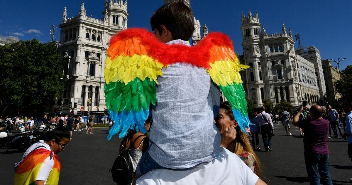 A child sporting rainbow wings is carried on shoulders in front of the Spain's Madrid city hall before the WorldPride 2017 parade in Madrid on July 1, 2017.