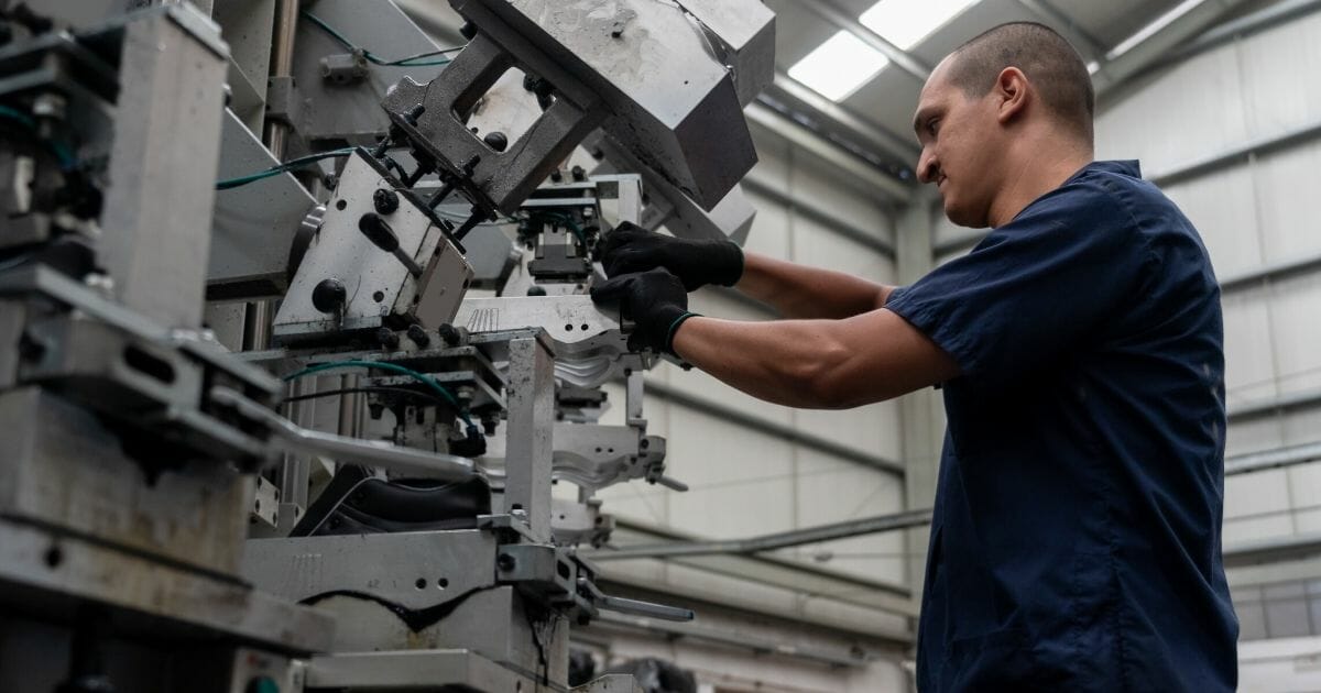 A worker operates machinery in a stock photo.