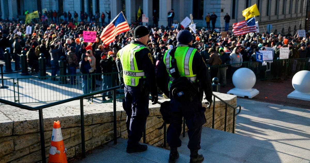 Virginia state police keep watch over a crowd gathered in front of the Virginia State Capitol in Richmond on Monday as an estimated 22,000 gun rights supporters massed near the state Capitol to demonstrate against proposed gun control laws.