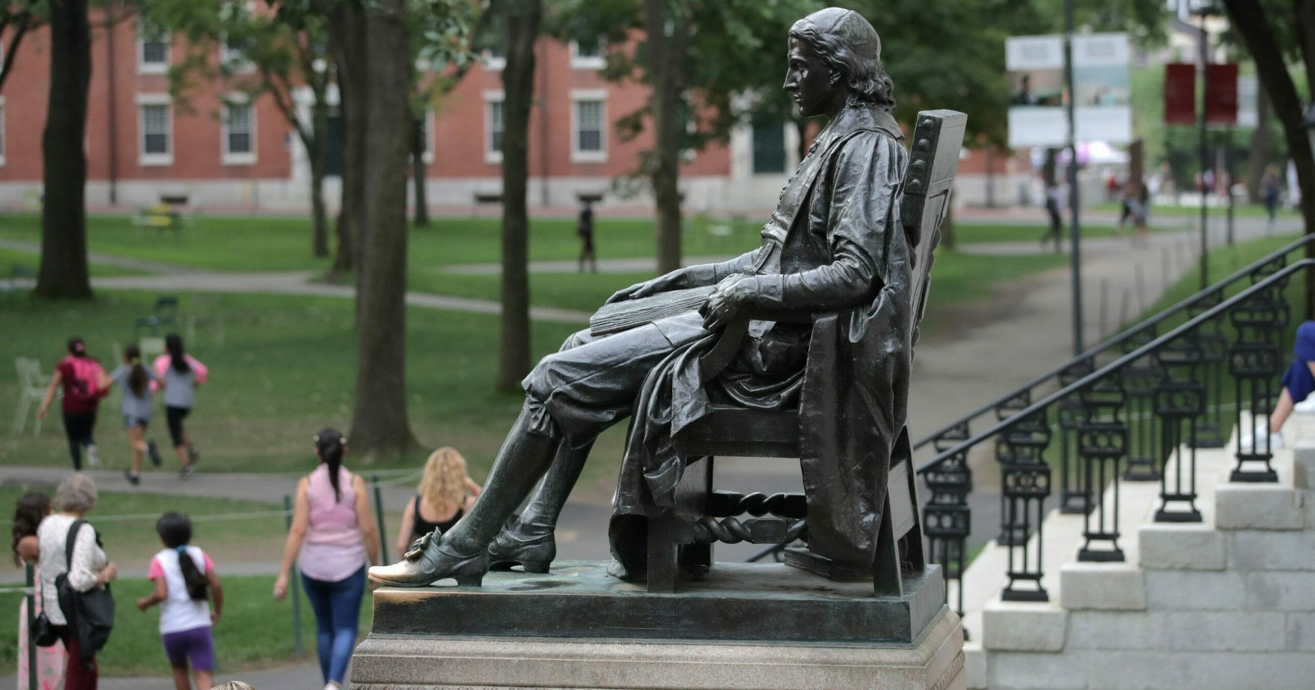 In this Aug. 13, 2019, file photo, the statue of John Harvard sits in Harvard Yard at Harvard University in Cambridge, Massachusetts.