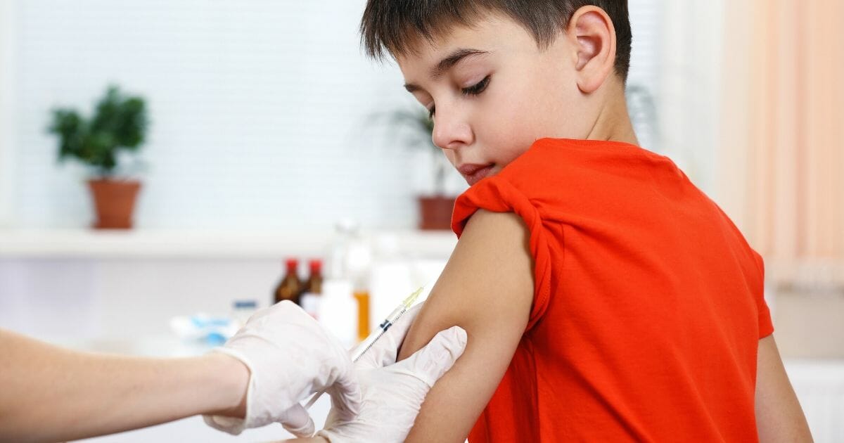 A boy is about to receive a drug via a syringe.