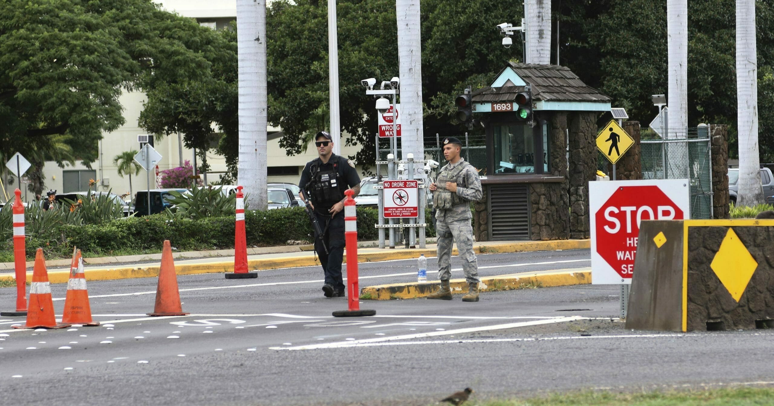 In this Dec. 4, 2019, file photo, security guards stand outside the main gate at Joint Base Pearl Harbor-Hickam in Hawaii. A live mortar round was found in a vehicle late Tuesday at a gate to the sprawling Pearl Harbor military base, shutting down the base for hours and leading three people to be taken into custody, military officials said Wednesday.