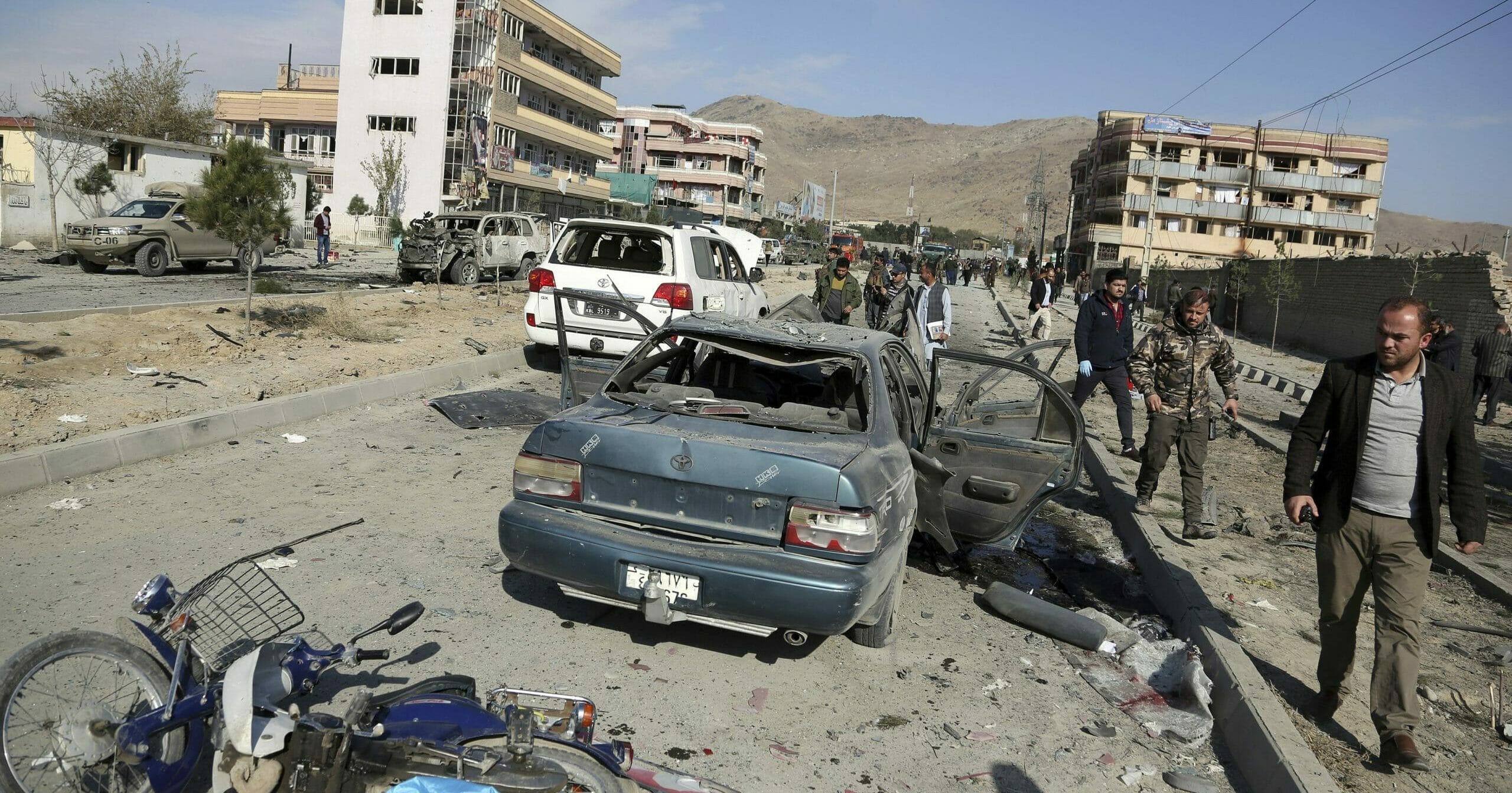 In this Nov. 13, 2019, file photo, Afghan security personnel gather at the site of a car bomb attack in Kabul, Afghanistan.