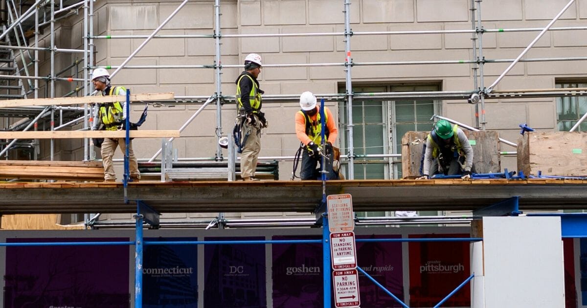Construction workers put up support scaffolding on the side of a building in Washington, D.C., on Oct. 8, 2019.