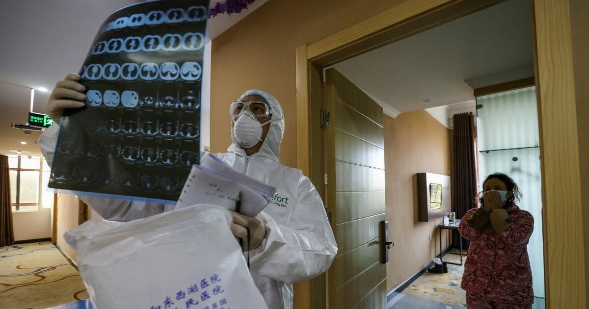 This photo taken on Feb. 3, 2020, shows a doctor looking at a lung CT image while making his rounds at a ward of a quarantine zone in Wuhan, the epicenter of the new coronavirus outbreak, in China's central Hubei province.