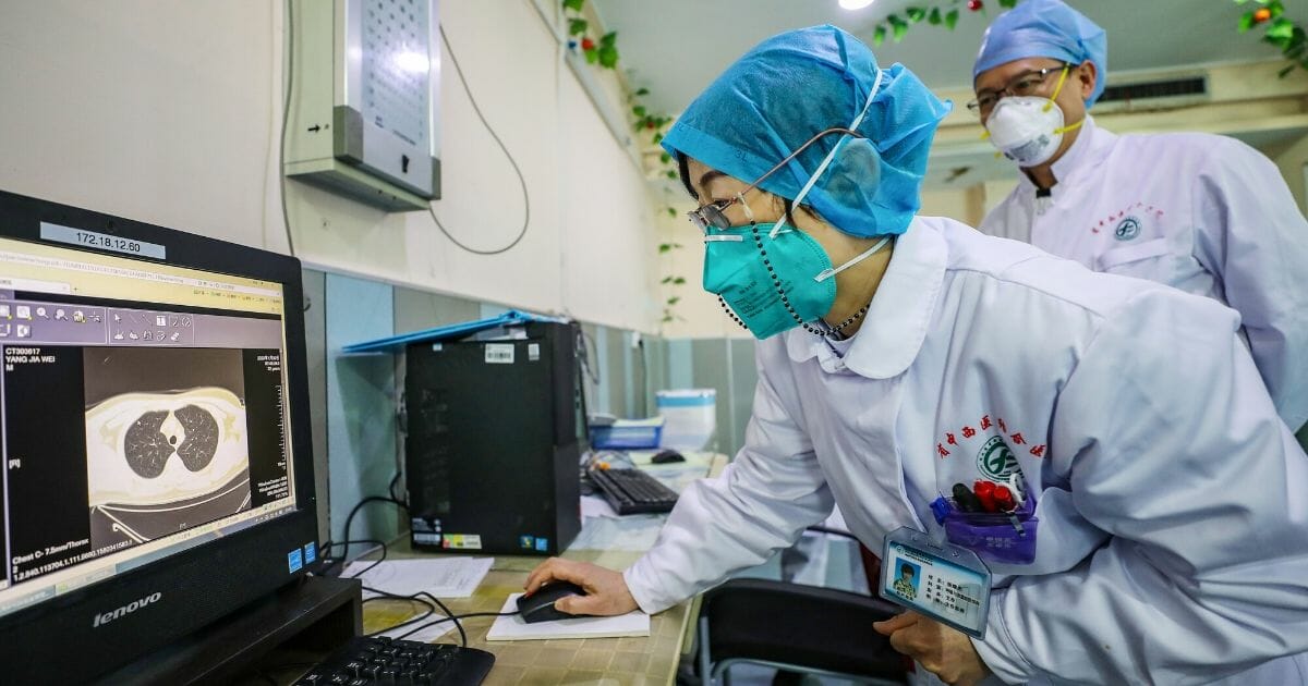 This photo taken on Jan. 30, 2020, shows a doctor wearing a facemask looking at a lung CT image from a patient at a hospital in Wuhan in China's central Hubei province, during the virus outbreak in the city.