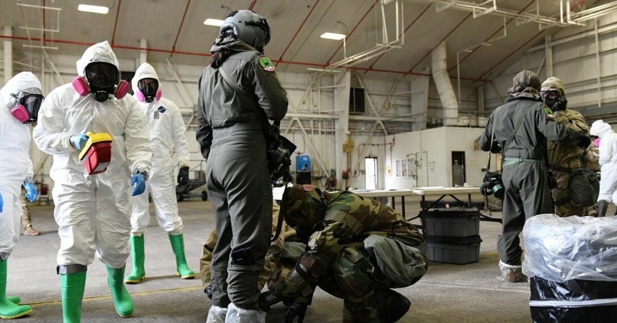 Airmen from the 19th Operations Support Squadron and 19th Medical Group bioenvironmental flight inspect a 41st Airlift Squadron Airman in a simulated decontamination line during a radiological aircraft recovery training exercise at Little Rock Air Force Base in Arkansas on Jan. 23, 2020.