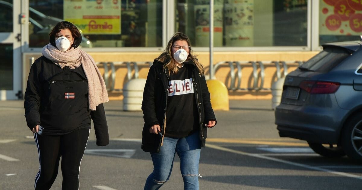 Women wearing a protective respiratory mask leave after finding out the local supermarket's closed in Codogno, southeast of Milan, on Feb. 22, 2020.