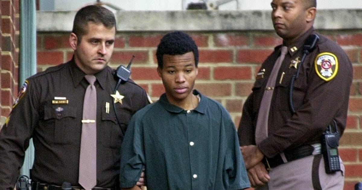 Beltway sniper John Lee Malvo is led by Fairfax County, Virginia, deputy sheriffs to a waiting van after a court appearance Nov. 19, 2002.