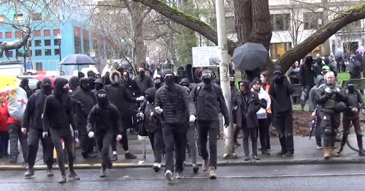 Masked antifa members threaten a journalist in Portland, Oregon.