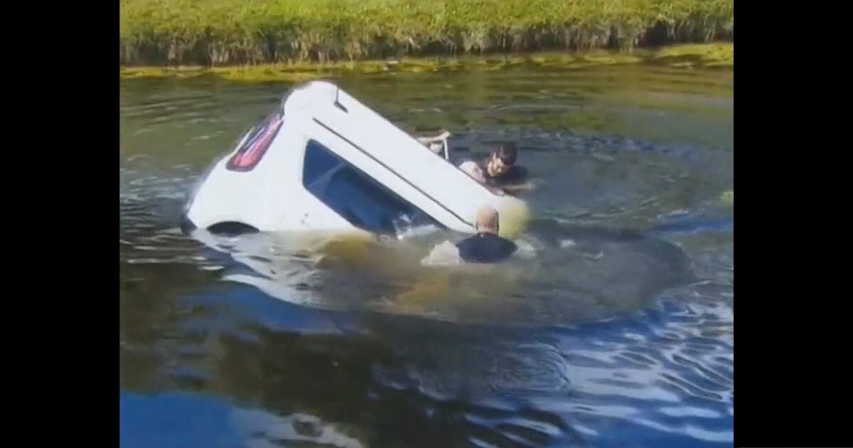 Good Samaritans rescue a woman trapped inside her sinking SUV in Boca Raton, Florida.