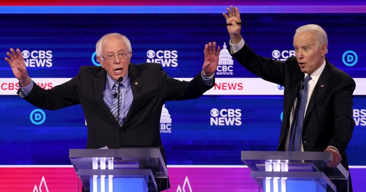 Democratic presidential candidates Sen. Bernie Sanders, left, and former Vice President Joe Biden try to make a point during the Democratic primary debate at the Charleston Gaillard Center in Charleston, South Carolina, on Feb. 25, 2020.