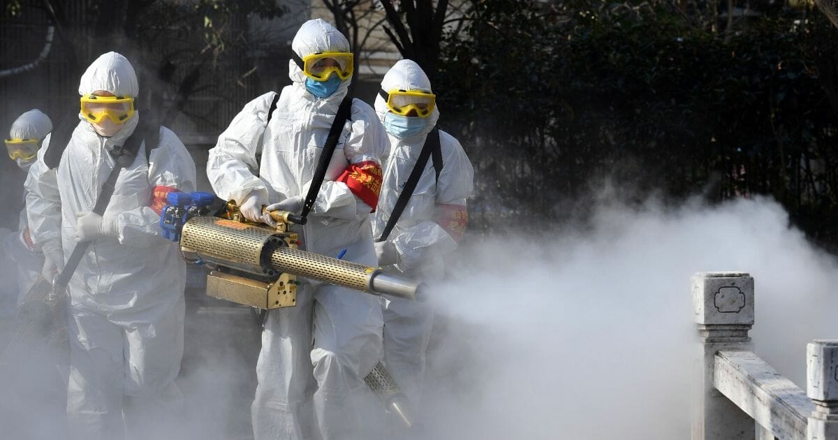 This photo taken on Feb. 18, 2020, shows members of a police sanitation team spraying disinfectant on a bridge as a preventive measure against the spread of the COVID-19 coronavirus in Bozhou, China.