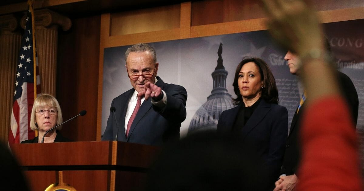 Senate Minority Leader Chuck Schumer points to a reporter at Friday's news conference while California Sen. Kamala Harris looks on.