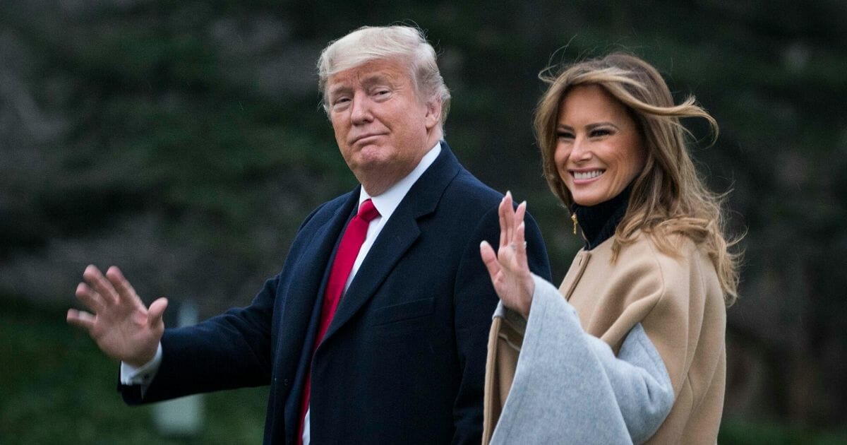 President Donald Trump and first lady Melania Trump wave to the cameras on the White House lawn as they walk to board Marine One on Friday.