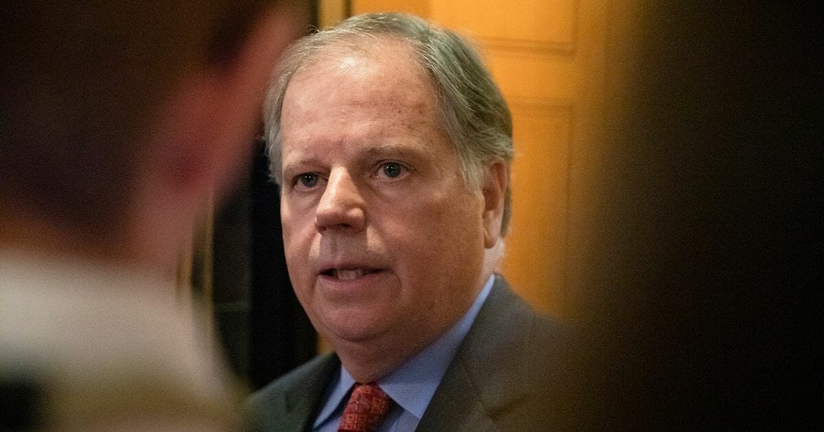 Democratic Sen. Doug Jones of Alabama answers questions from reporters after leaving the Senate floor where he announced that he will be voting to convict in the Senate impeachment trial of President Donald Trump on Feb. 5, 2020, in Washington, D.C.