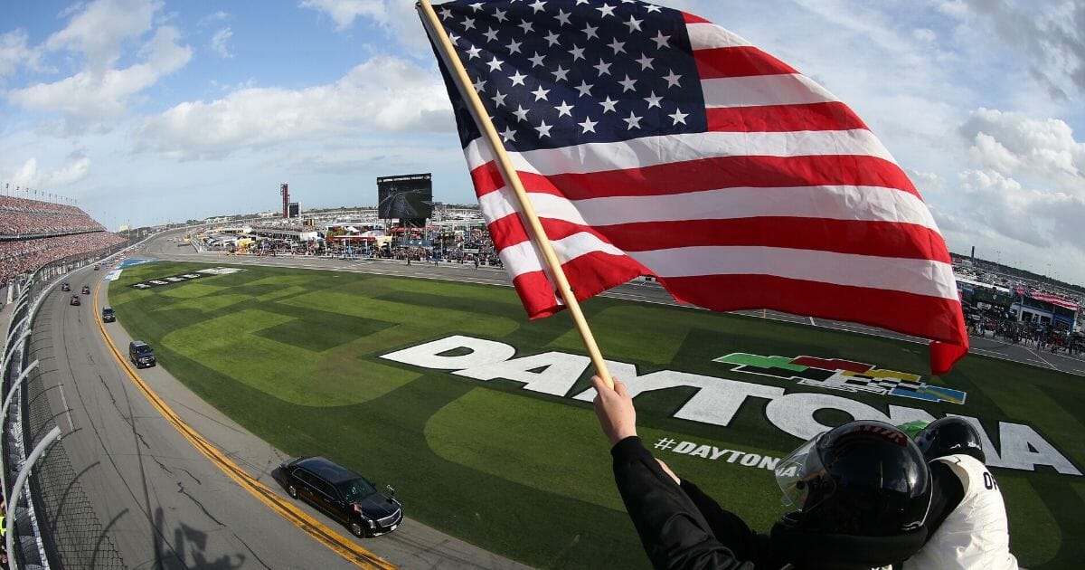 An American flag waves as President Donald Trump's limousine cirlcles the track at the Daytona 500 on Sunday.