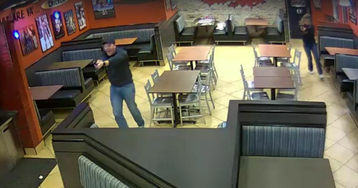 Off-duty police officers Chase and Nicole McKeown draw their weapons at a Raising Cane's restaurant in Louisville, Kentucky.