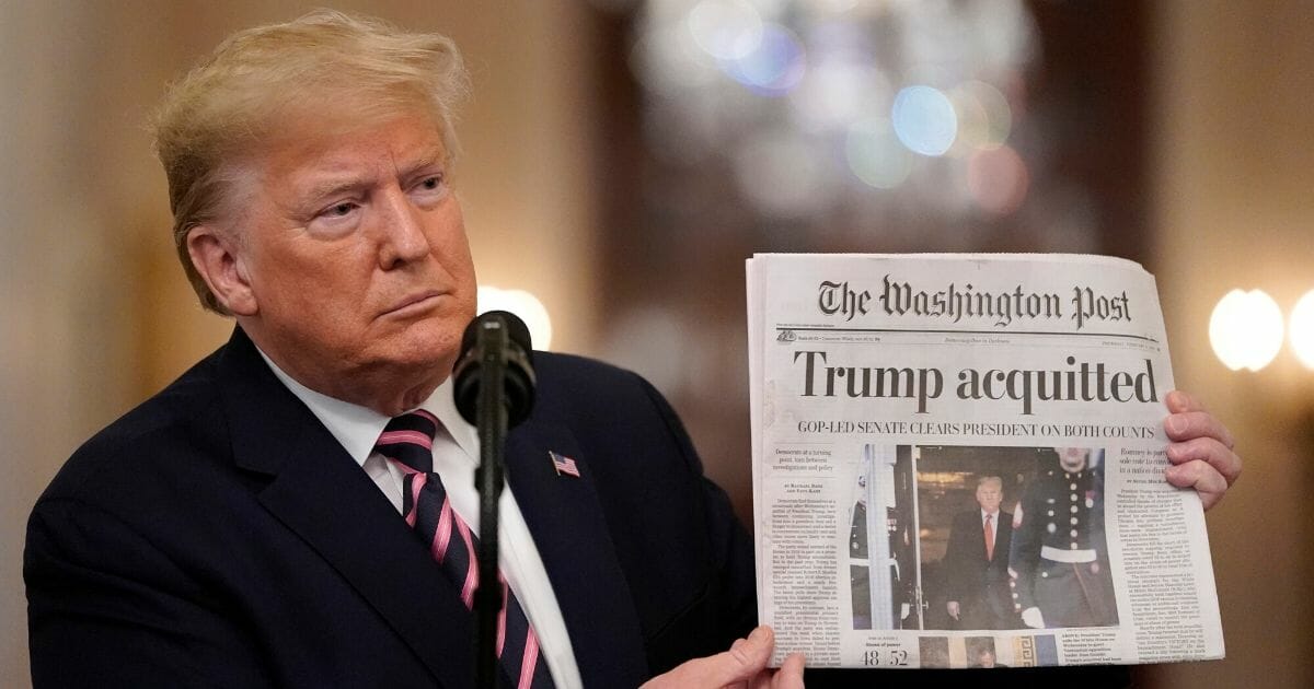 President Donald Trump holds a copy of The Washington Post as he speaks in the East Room of the White House on Feb. 6, 2020, one day after the Senate acquitted him on two articles of impeachment.