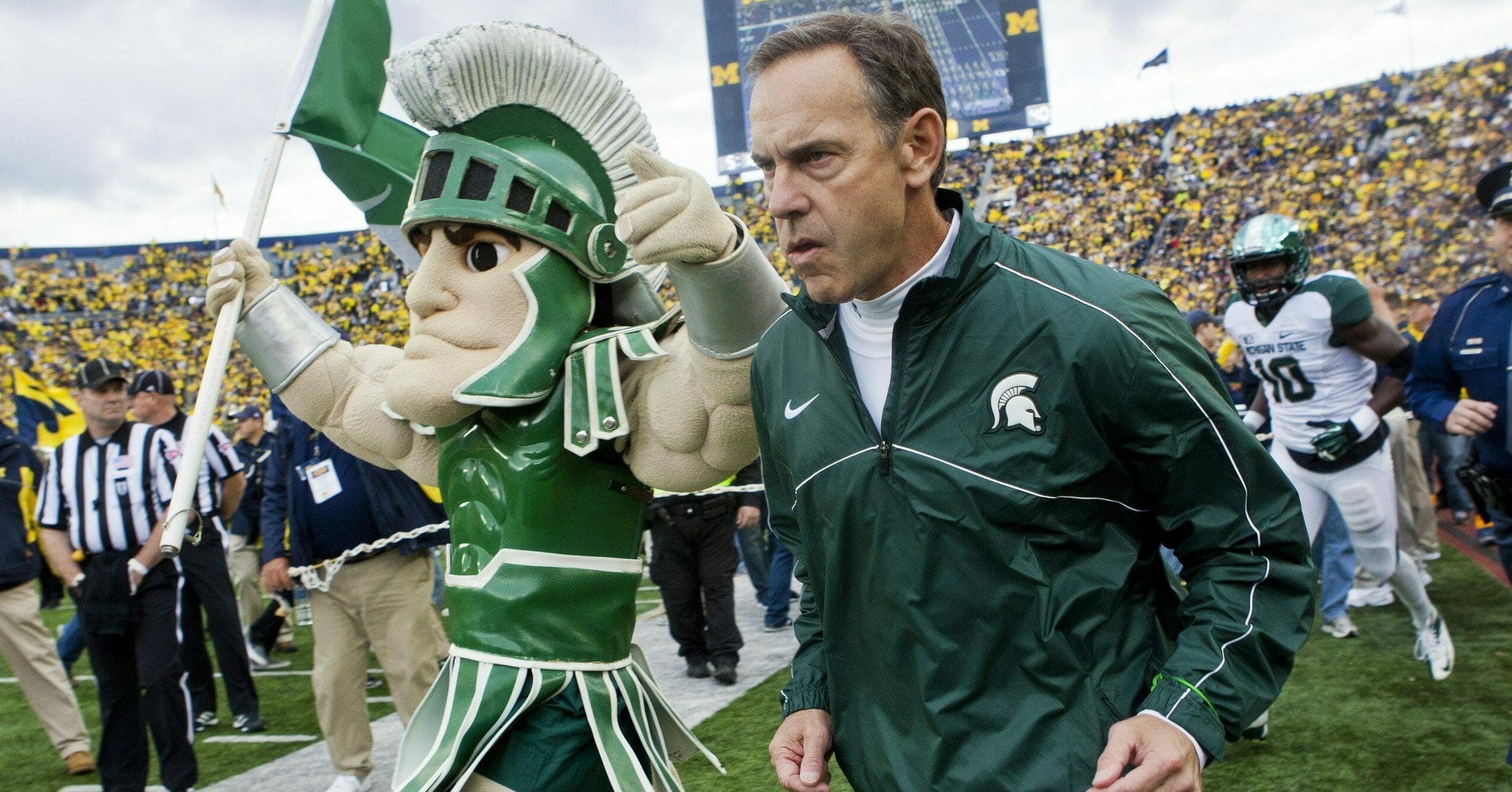 Michigan State head coach Mark Dantonio, right, runs out on to the Michigan Stadium field alongside the school mascot, Sparty, before an Oct. 20, 2012, game against Michigan in Ann Arbor.