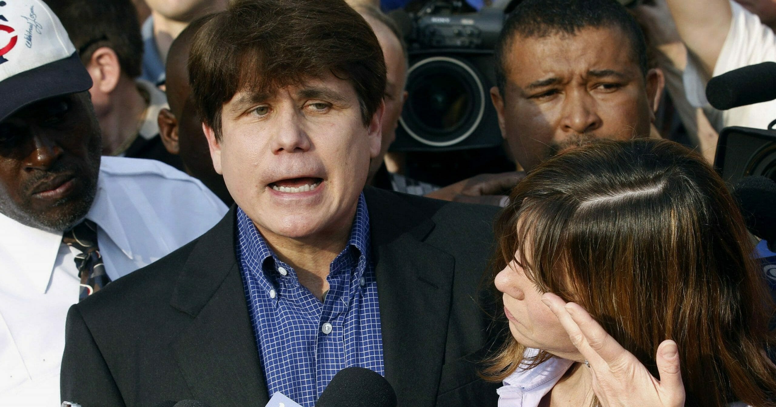 Former Illinois Gov. Rod Blagojevich speaks to the media outside his home in Chicago on March 14, 2012, as his wife, Patti, wipes away tears a day before he reported to prison after his conviction on corruption charges.