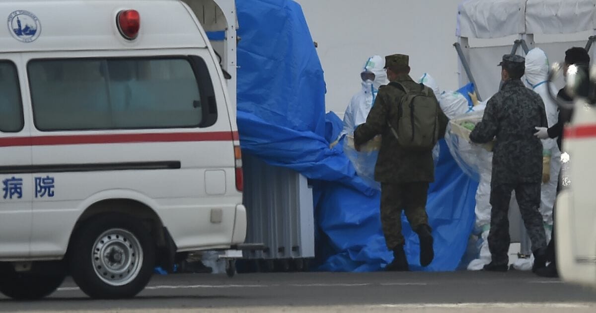 Military personnel and medical staff clad in protective gear