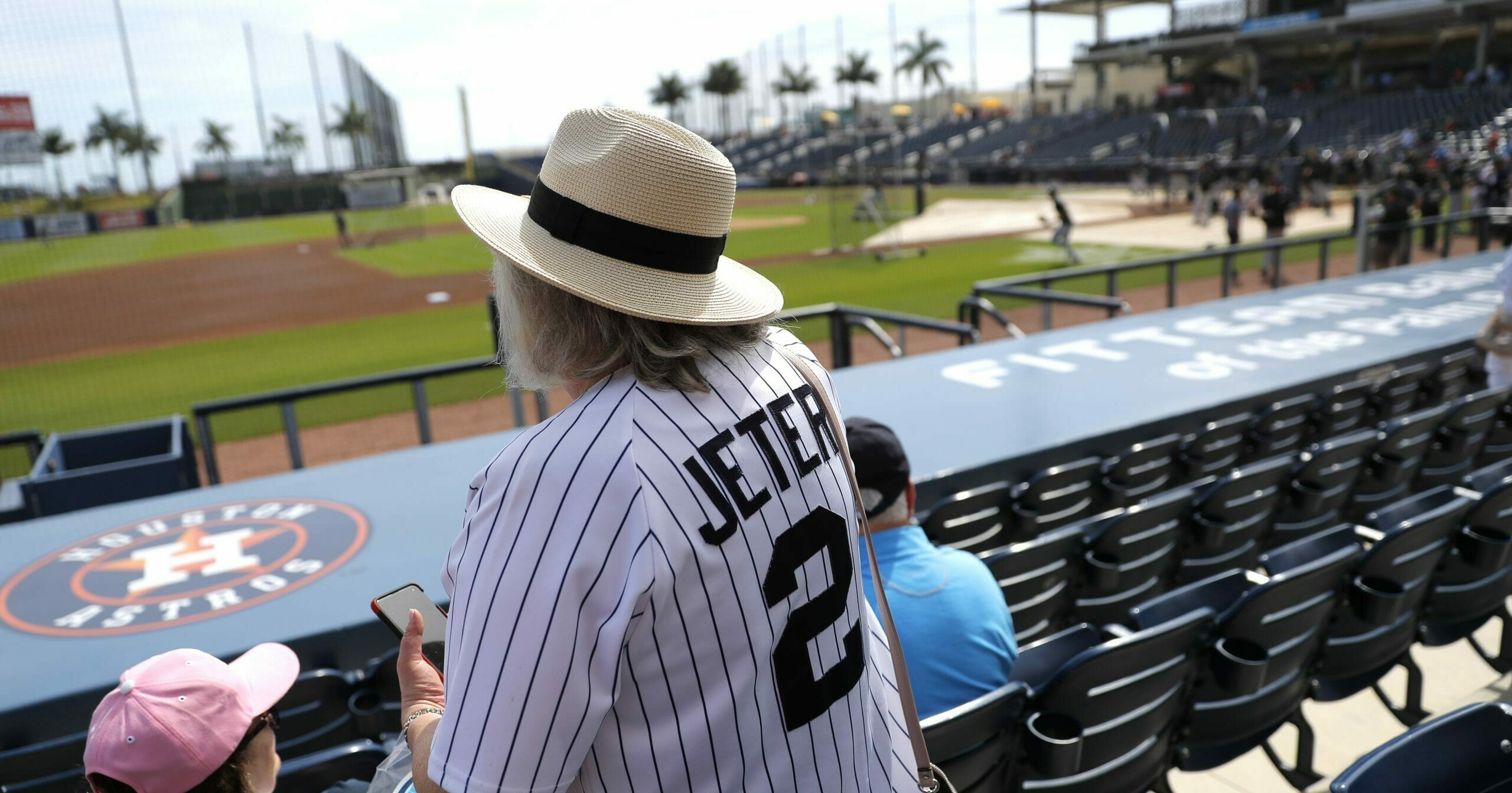 A woman wearing a Derek Jeter jersey settles into her seat prior to a spring training game between the New York Yankees and the Washington Nationals on March 12, 2020, in West Palm Beach, Florida.