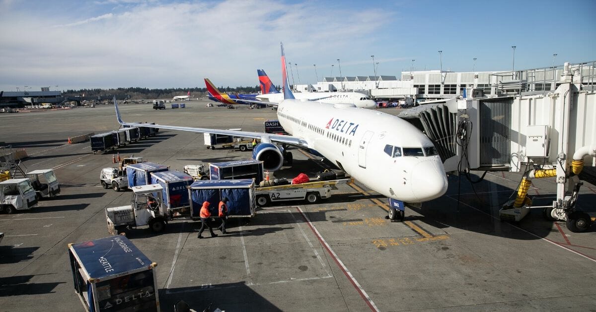 A ground crew prepares to unload luggage from an arriving Delta Airlines flight at the Seattle-Tacoma International Airport on March 15, 2020, in Seattle, Washington.