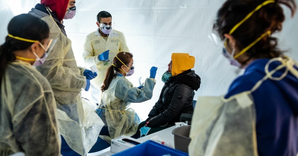 Doctors test hospital staff with flu-like symptoms for coronavirus in tents outside the emergency department at St. Barnabas hospital in the Bronx, New York, on March 24, 2020.