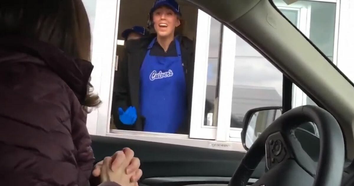 Michelle Floering of Grand Traverse Academy in Traverse City, Michigan, tells valedictorian Kaitlyn Watson the good news at the drive-thru window of the Culver's where Watson works.