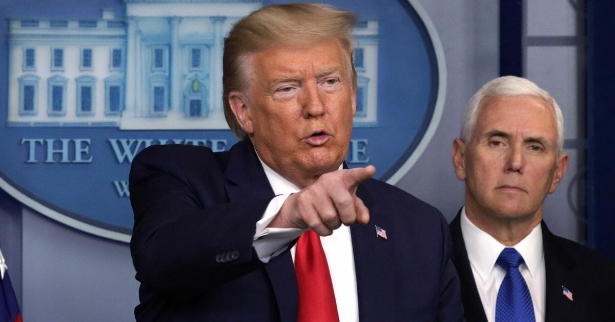 President Donald Trump speaks as Vice President Mike Pence listens during a news briefing on the latest development of the coronavirus outbreak in the U.S. at the James Brady Press Briefing Room at the White House on March 18, 2020, in Washington, D.C.