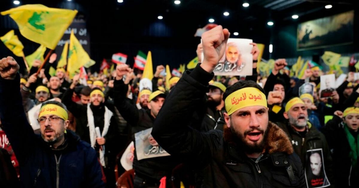 Supporters of the Shiite Hezbollah movement react with clenched fists as the movement's leader delivers a speech on Jan. 5, 2020.