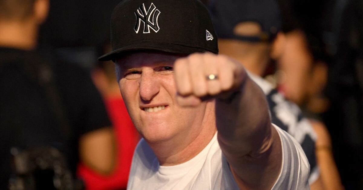 Actor Michael Rapaport grimaces and makes a fist while wearing a New York Yankees cap.