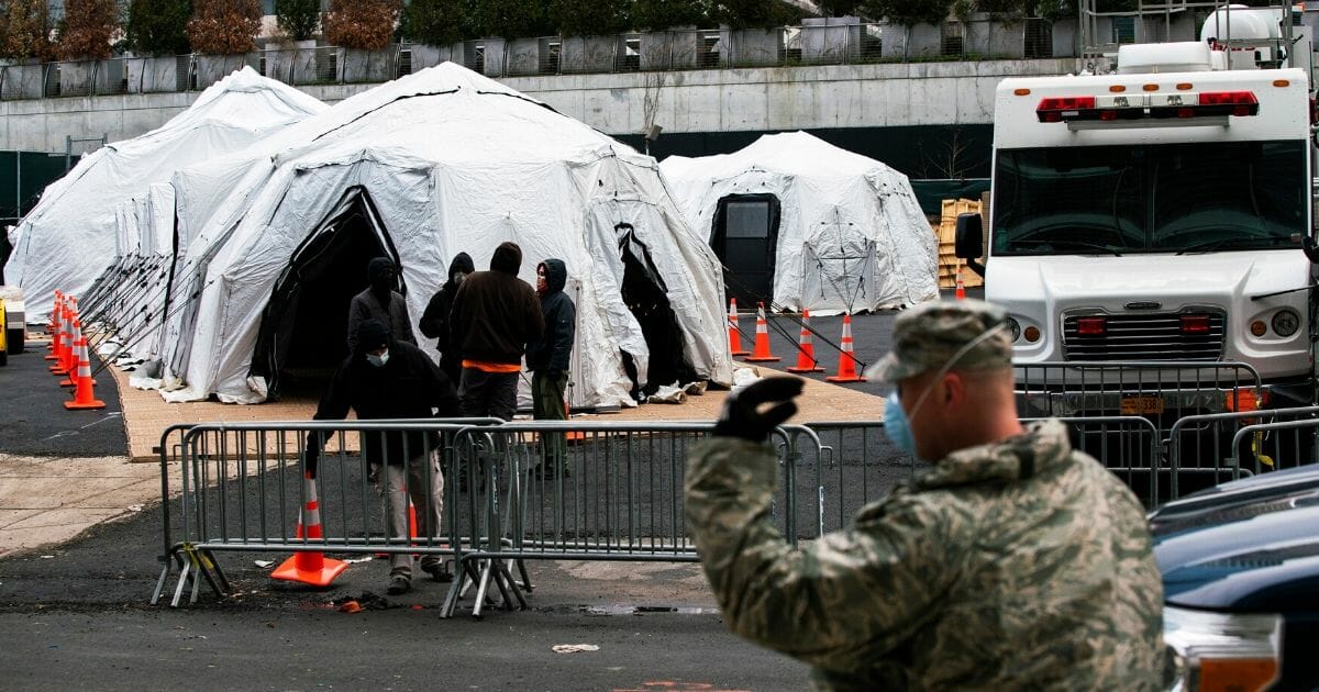 Workers and members of the National Guard build a makeshift morgue outside of Bellevue Hospital on March 25, 2020, in New York City.