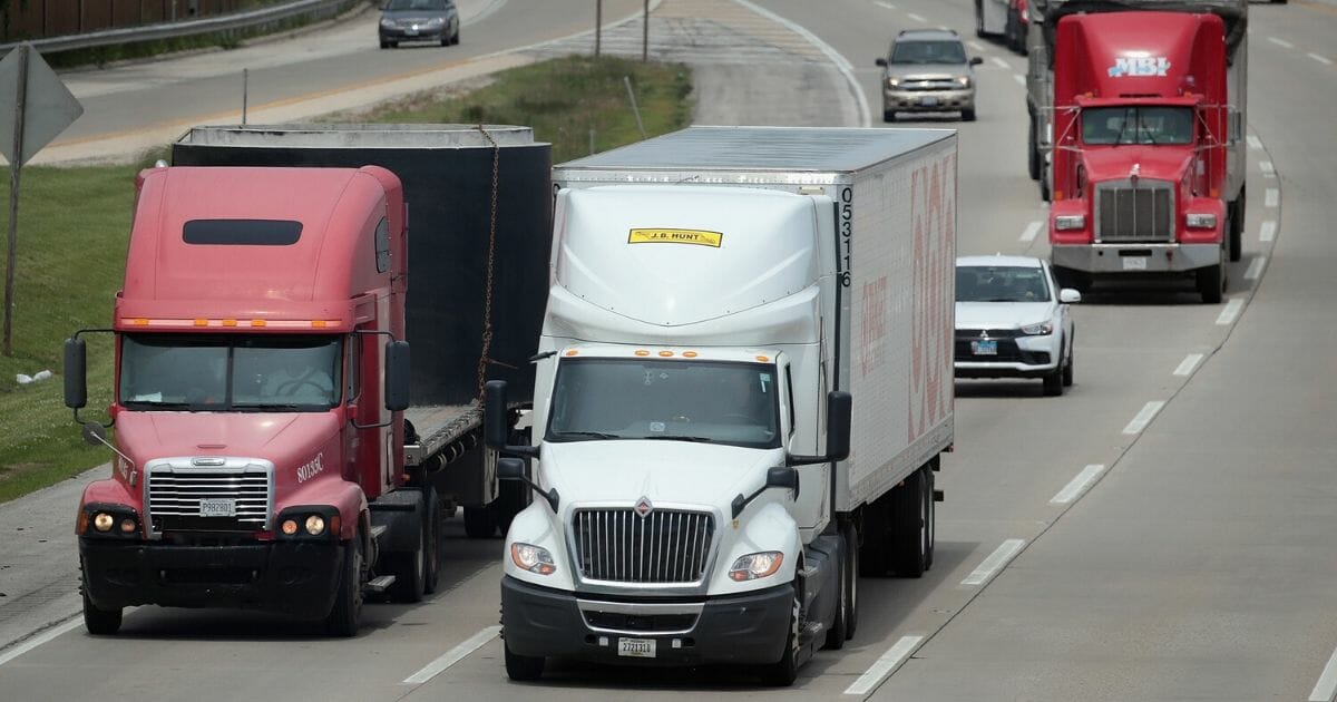 Semi trucks travel along the interstate on June 21, 2019, near Lake Forest, Illinois.