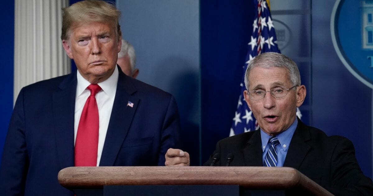 Dr. Anthony Fauci, director of the National Institute of Allergy and Infectious Diseases, speaks as President Donald Trump looks on during a briefing on the coronavirus pandemic at the White House on March 24, 2020.
