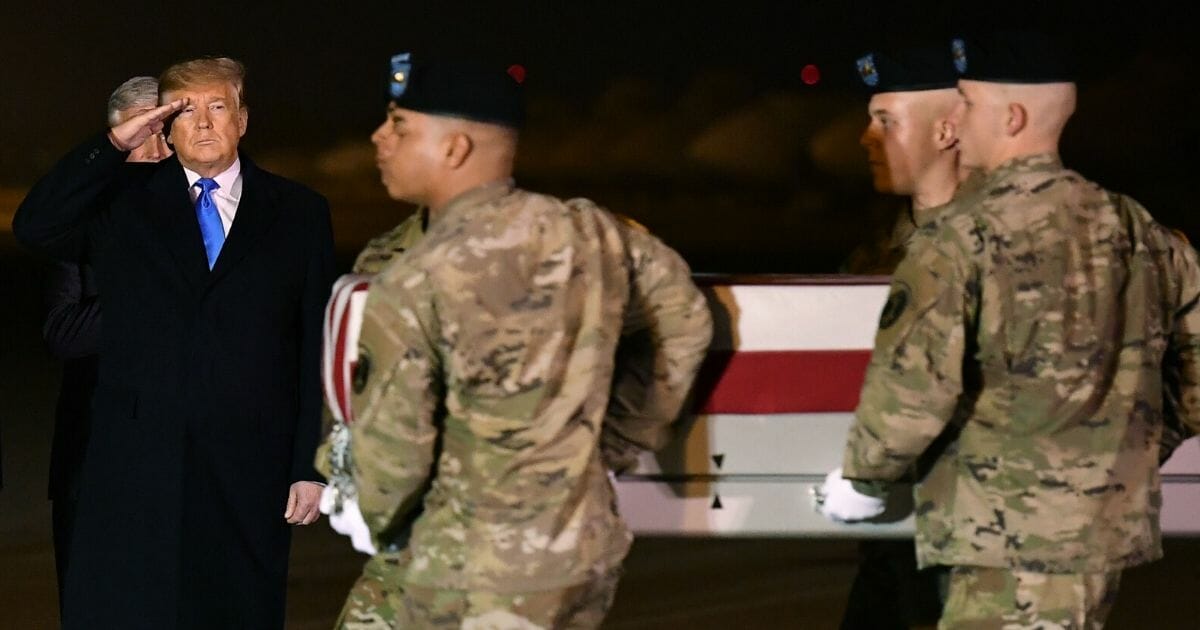 President Donald Trump salutes as the remains of Chief Warrant Officer 2 David C. Knadle, who was killed in Afghanistan, are carried during a dignified transfer at Dover Air Force Base in Delaware on Nov. 21, 2019.