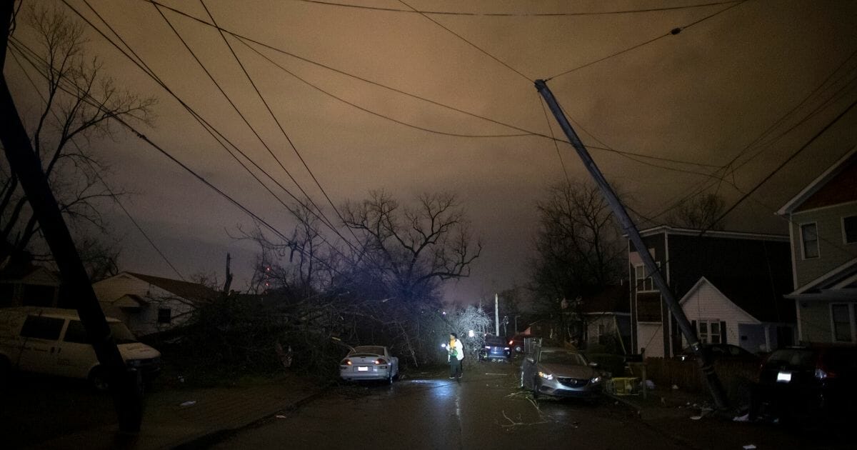 A resident makes her way down Underwood St. amidst downed trees and heavy debris on March 3, 2020, in Nashville, Tennessee.