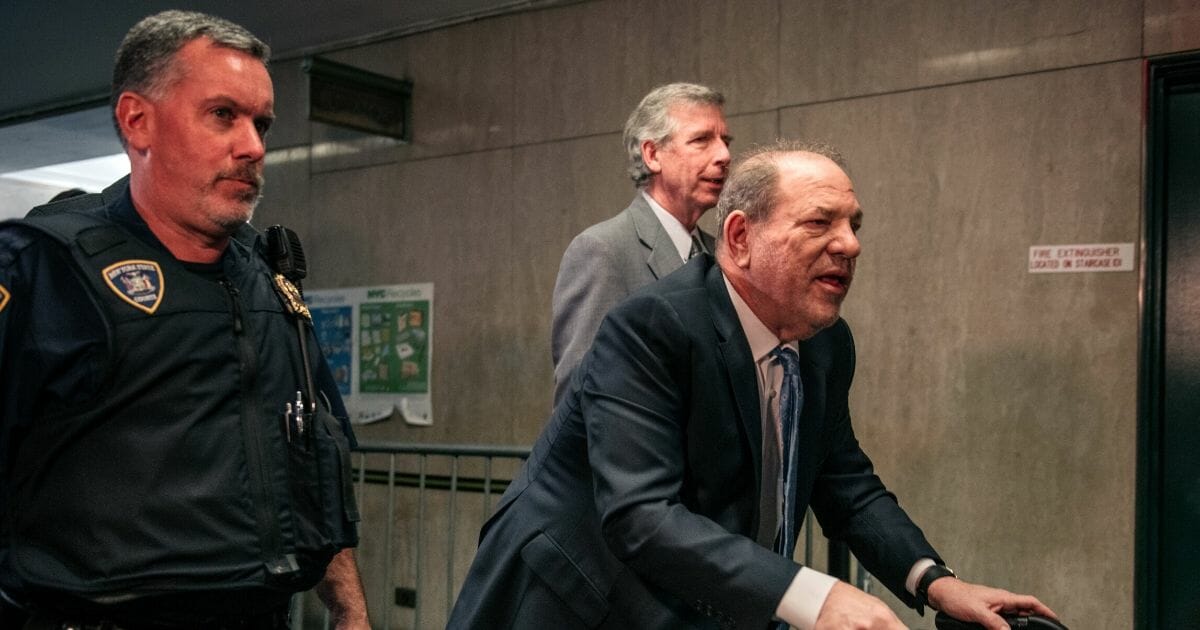 Former Hollywood movie producer Harvey Weinstein, right, enters New York City Criminal Court on Feb. 24, 2020, in New York City.