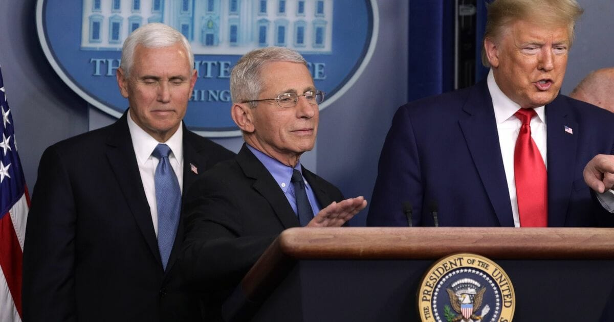 Dr. Anthony Fauci, National Institute for Allergy and Infectious Diseases director, gestures as President Donald Trump speaks Saturday during a news conference in the White House.