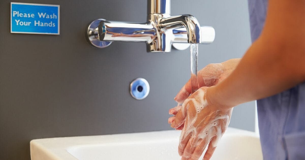 Close-up of a medical professional washing her hands.
