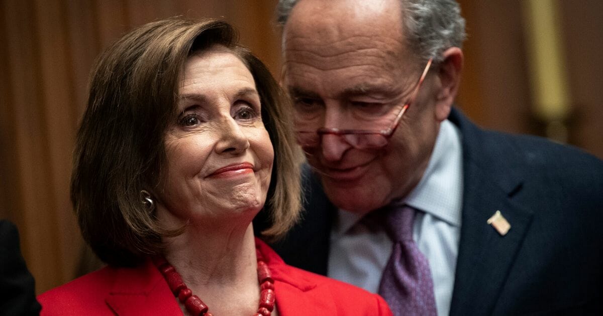 House Speaker Nancy Pelosi grins as she and Senate Minority Leader Chuck Schumer share a moment of consultation in a November file photo.