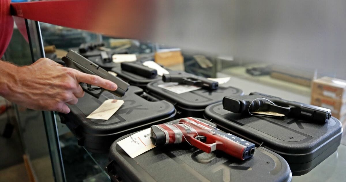 A worker restocks handguns at Davidson Defense in Orem, Utah, on Friday.