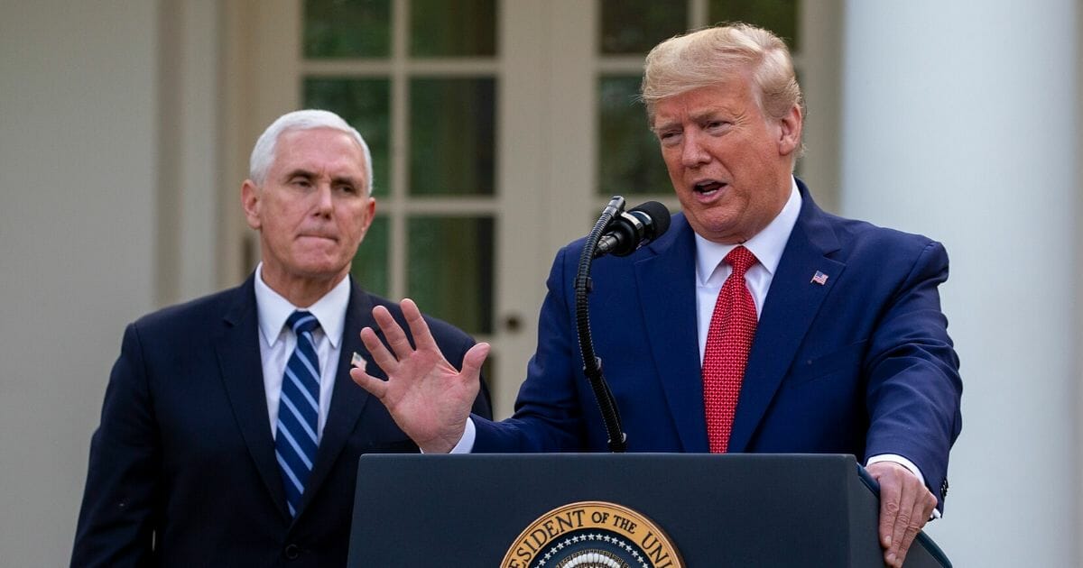Vice President Mike Pence listens to President Donald Trump speak in the Rose Garden for the daily coronavirus briefing at the White House on March 29, 2020.