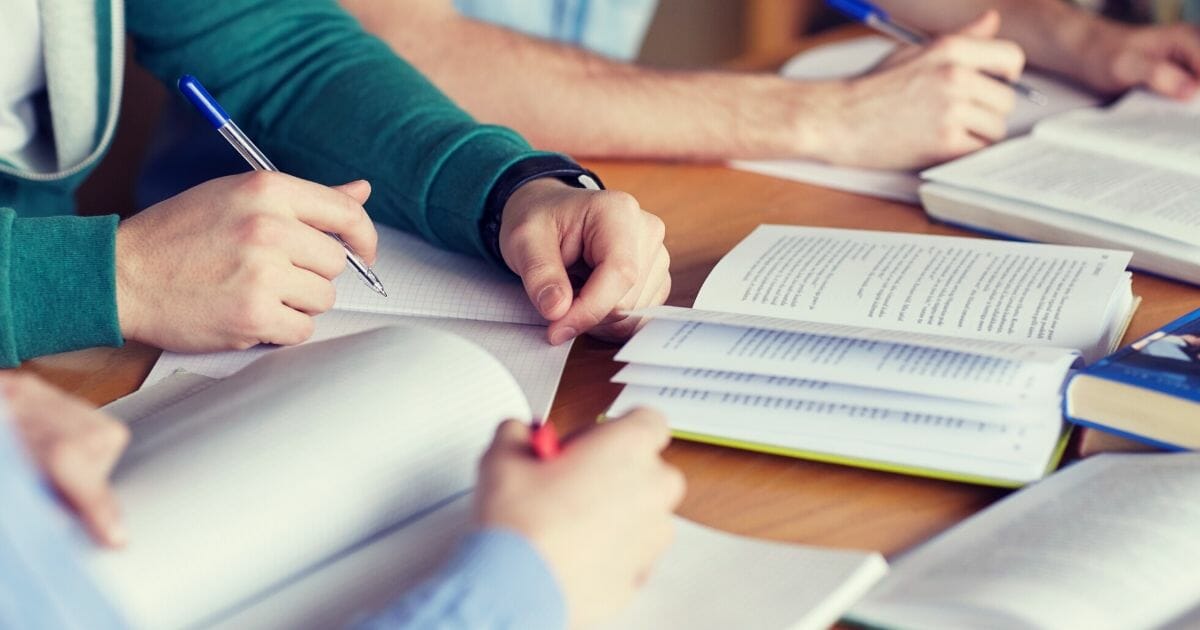 Stock image of students studying with books and other materials.