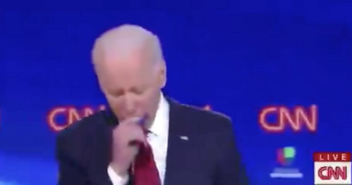 Joe Biden coughs into his hand during the Democratic presidential primary debate on March 15, 2020, in Washington, D.C.