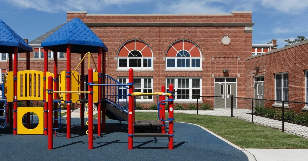 Stock image of a playground and elementary school.
